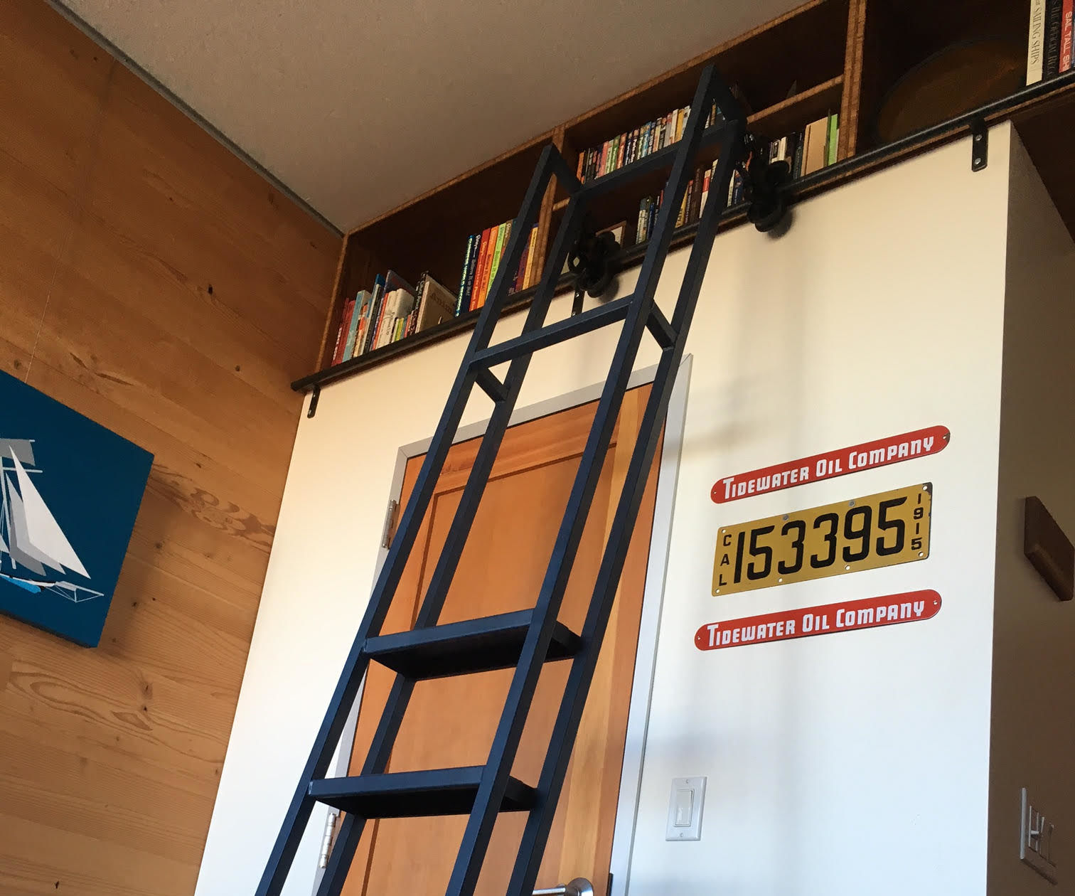 Ceiling bookshelf with library ladder